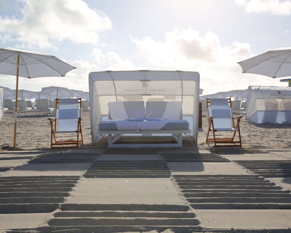 A groomed public beach at dawn, umbrella rows waiting for the day.