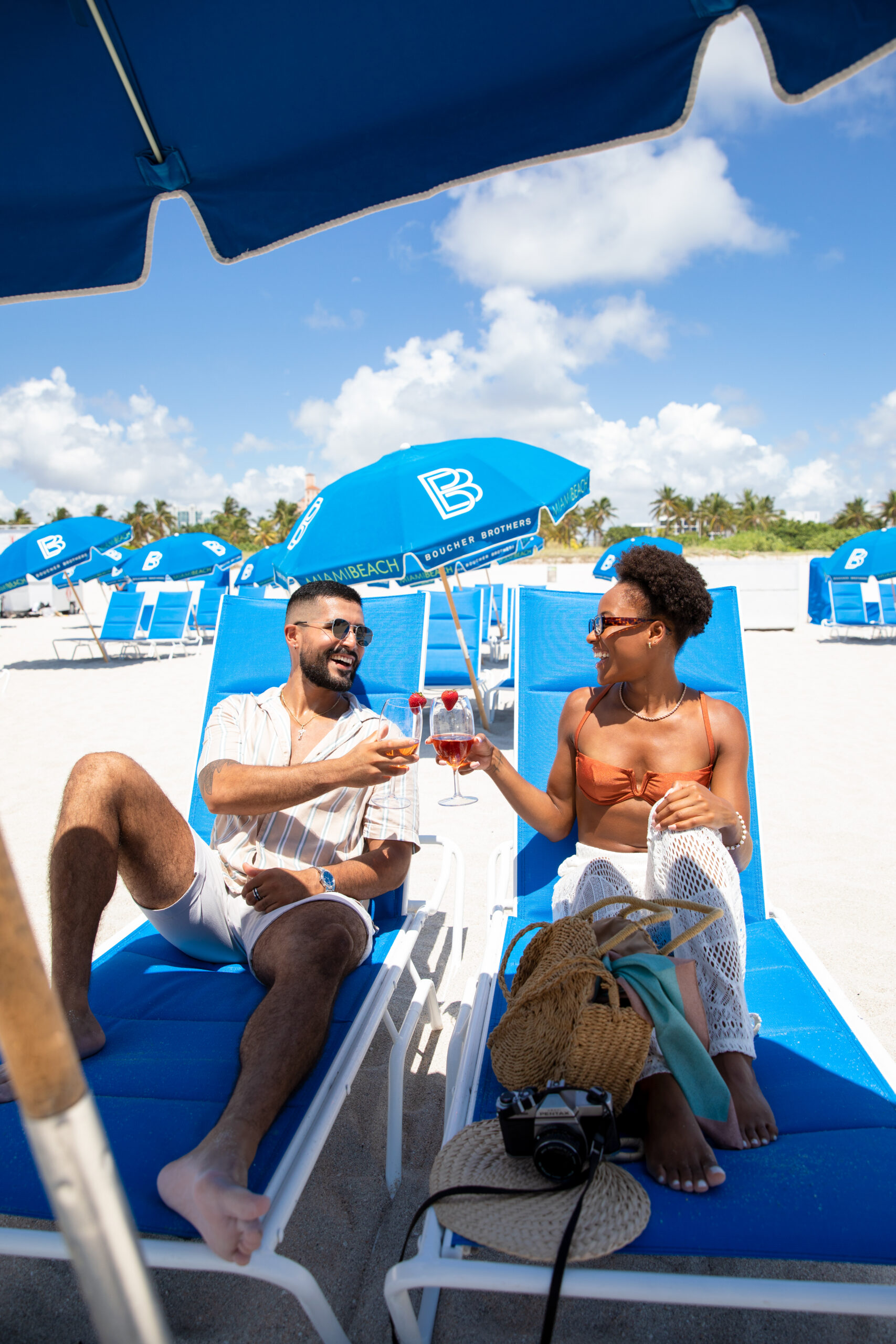 Members toasting from their reserved loungers beneath a branded umbrella.