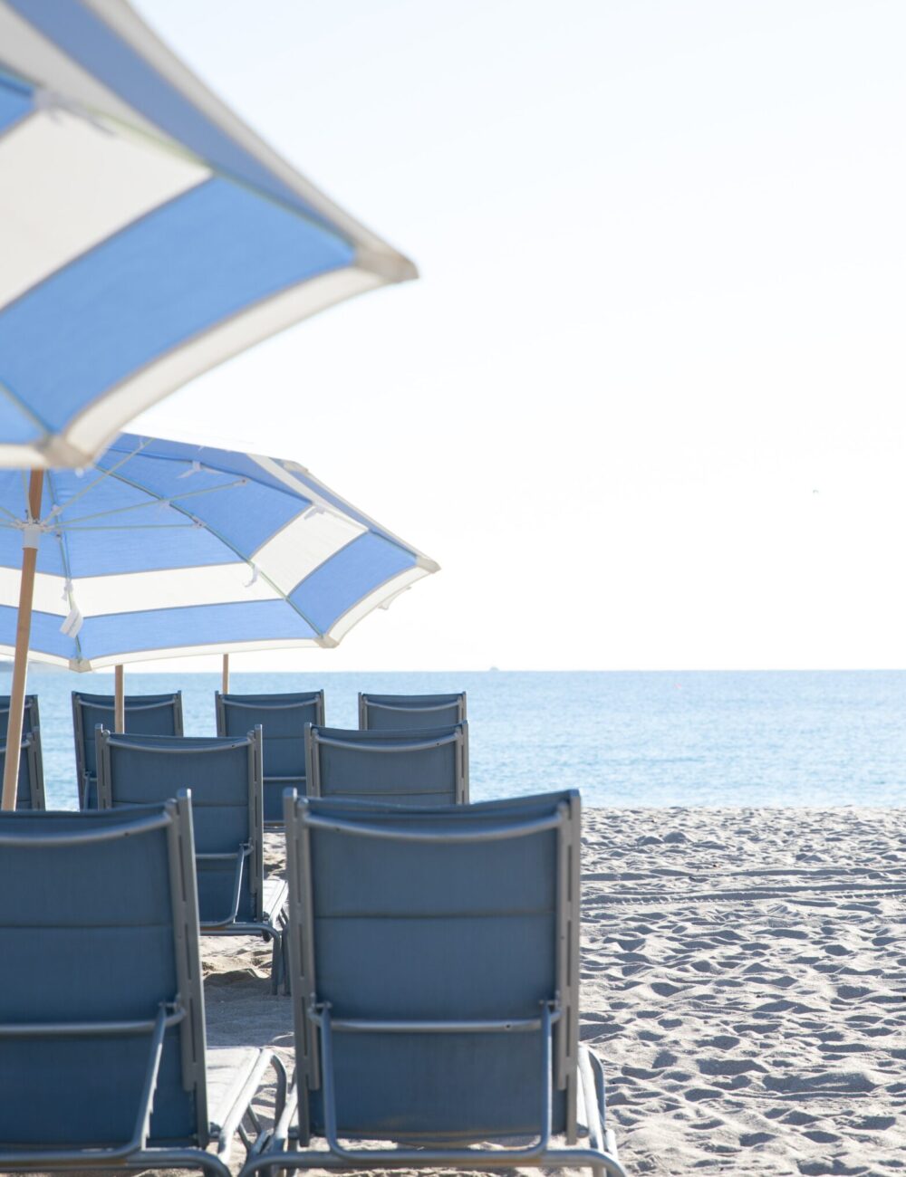 Custom outdoor furniture staged on a private beach terrace.