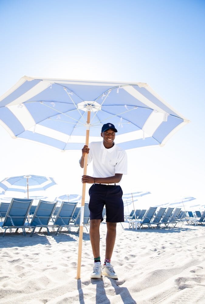 A Boucher Brothers attendant setting umbrellas in the first light of morning.
